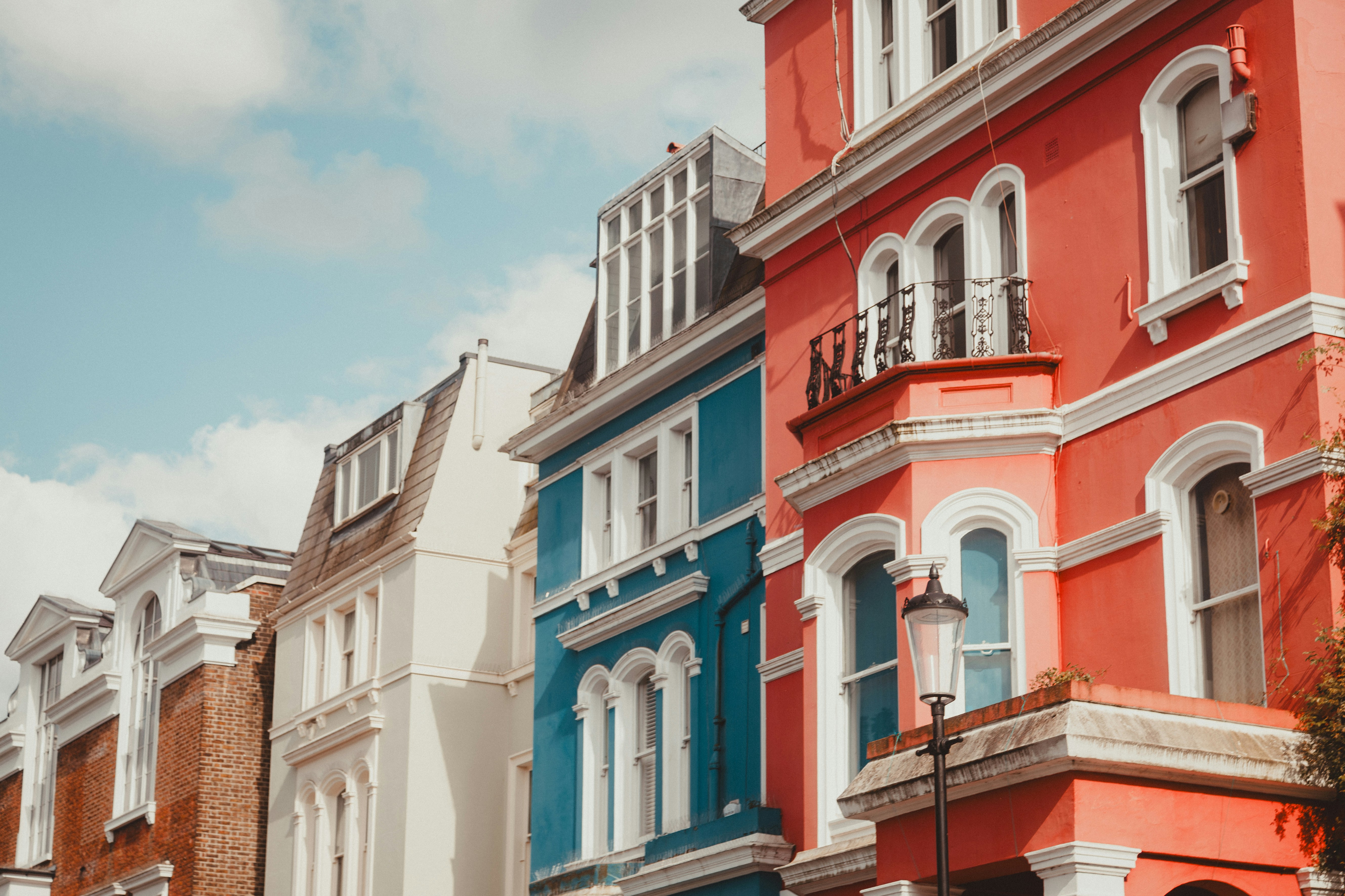 Colorful pastel townhouses lining a residential street in Notting Hill, London
