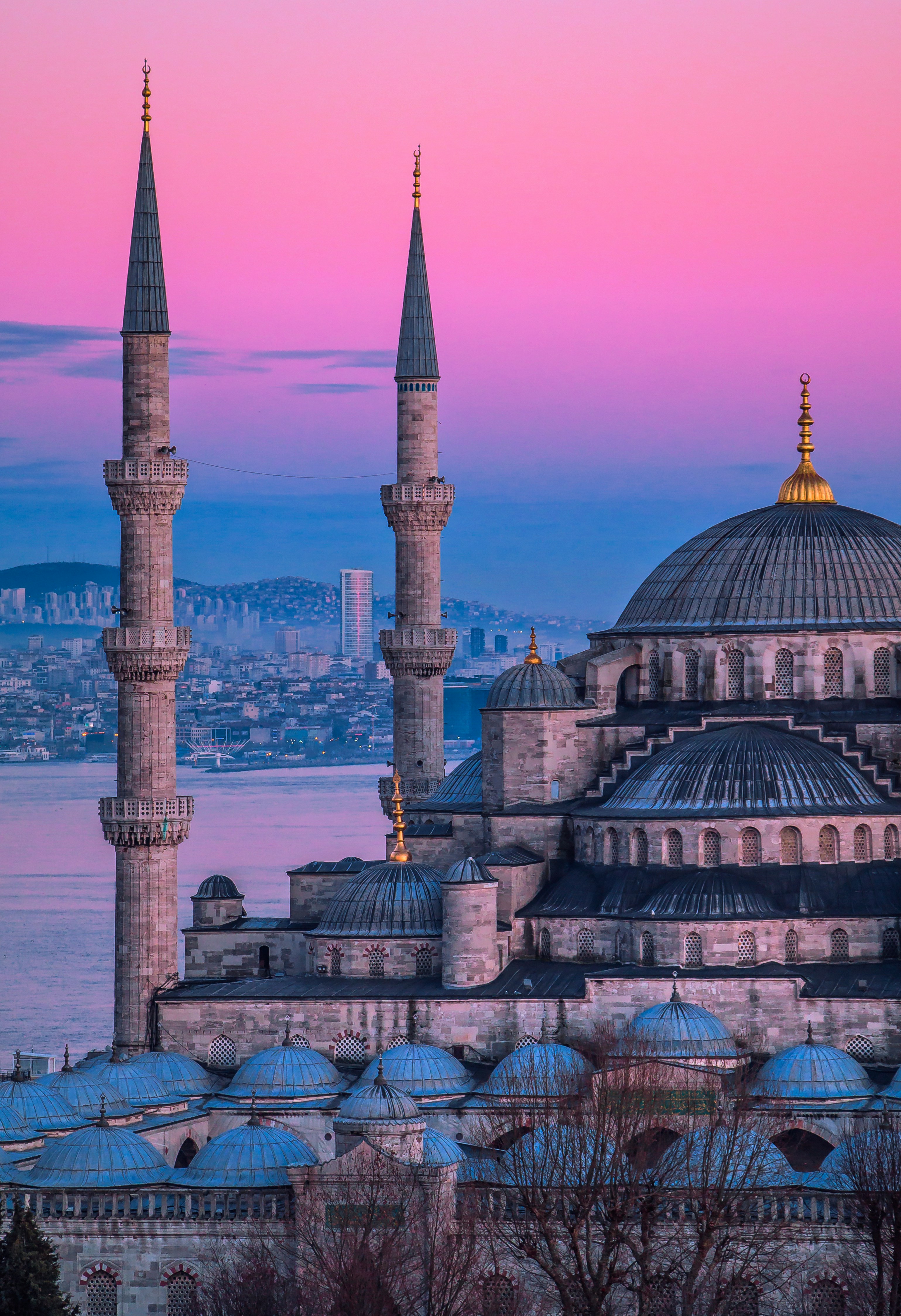 The Istanbul skyline at dusk, minarets and domes reflected in the Bosphorus